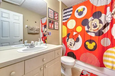 a bathroom with a toilet and a shower curtain at Magical Getaway Close to Disney! Pool, Gym, & WiFi in Kissimmee