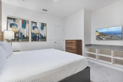 a white bedroom with a bed and paintings on the wall at Brand NEW 12Bedrooms12Bathroom At Paradiso Grande in Orlando