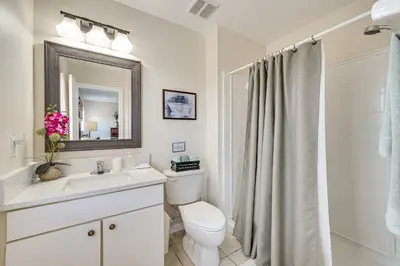 a bathroom with a toilet and a sink and a mirror at 7 Mi to Disney Kissimmee Poolside Paradise! in Kissimmee