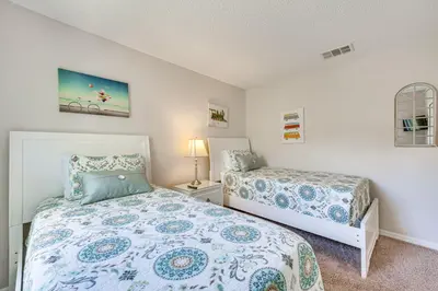 a small bedroom with two beds and a lamp at 7 Mi to Disney Kissimmee Poolside Paradise! in Kissimmee