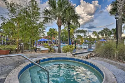 a hot tub at a resort with palm trees at 7 Mi to Disney Kissimmee Poolside Paradise! in Kissimmee