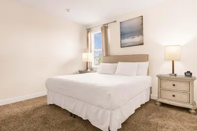 a bedroom with a large white bed and a nightstand at Your Dream Vacation Awaits Family 10-Bd Villa in Orlando