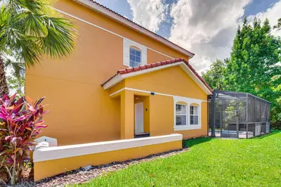 a yellow house with a greenhouse in the yard at Private Pool Family-Friendly Kissimmee Townhome! in Kissimmee