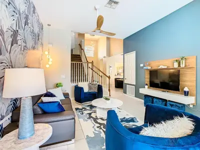 a living room with blue furniture and a tv at WH7742CS - Newly renovated villa in Windsor Hills in Orlando