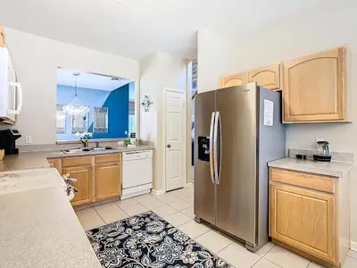 a kitchen with a stainless steel refrigerator and wooden cabinets at WH7742CS - Newly renovated villa in Windsor Hills in Orlando