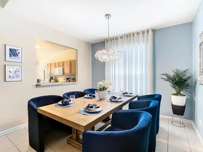 a dining room with a table and blue chairs at WH7742CS - Newly renovated villa in Windsor Hills in Orlando
