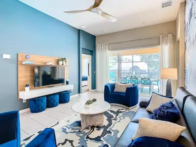 a living room with blue furniture and a flat screen tv at WH7742CS - Newly renovated villa in Windsor Hills in Orlando