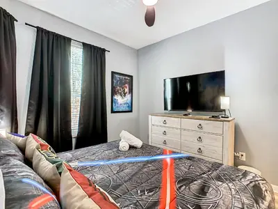 a bedroom with a bed and a dresser with a television at WH2778-201AL - Toy Story meets Star Wars in Orlando
