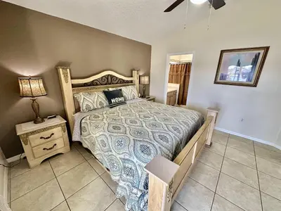 a bedroom with a bed and a lamp on a table at EP1015SEL - 4 bedrooms - 8 guests pool home on a lake in Kissimmee