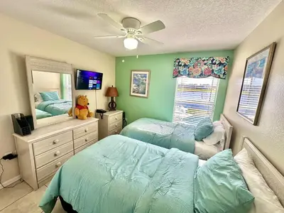 a bedroom with two twin beds and a mirror at EP1015SEL - 4 bedrooms - 8 guests pool home on a lake in Kissimmee