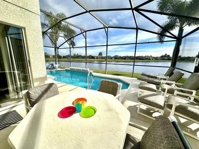 a white table with a toy on it next to a pool at EP1015SEL - 4 bedrooms - 8 guests pool home on a lake in Kissimmee
