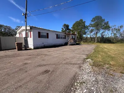 an empty road in front of a white house at Mobile Home on huge parking space 10 mins from airport, 20 mins from Disney in Kissimmee