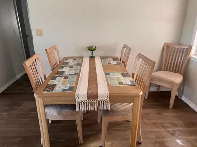 a wooden table with four chairs and a vase on it at Mobile Home on huge parking space 10 mins from airport, 20 mins from Disney in Kissimmee