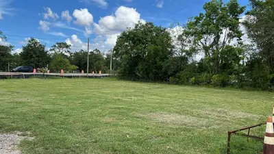 a field of grass with a car in the background at Mobile Home on huge parking space 10 mins from airport, 20 mins from Disney in Kissimmee