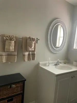 a bathroom with a sink and a mirror and towels at Mobile Home on huge parking space 10 mins from airport, 20 mins from Disney in Kissimmee