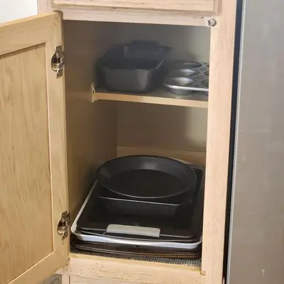 a cabinet with a pot and pans in it at 4 Bedroom villa in Lake Berkley, Private Pool Fantastic View, Free WiFi, Theme Parks All Around! in Kissimmee