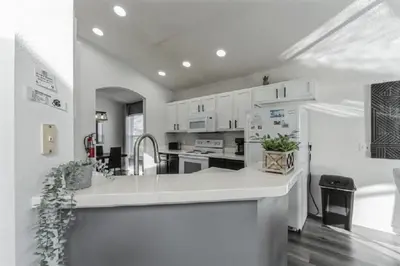 a kitchen with white cabinets and a white refrigerator at 637- Huge 5 Bed Villa with Amazing Water Views and Own Private Pool and Spa in Kissimmee