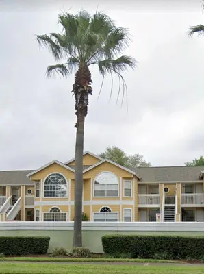 a palm tree in front of a building at Spacious Condo Close to Disney Attractions in Kissimmee