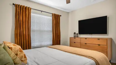 a bedroom with a bed and a television on a dresser at Beautiful 7 Bed Family Pool Home with Game Room-8510PHD in Kissimmee