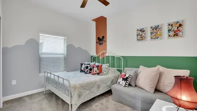 a childs bedroom with a crib and a couch at Canoe Landing in Orlando