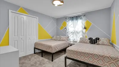 a bedroom with two beds and a door and a chair at Canoe Landing in Orlando
