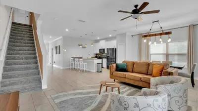 a living room with a couch and a kitchen at Canoe Landing in Orlando
