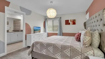 a bedroom with a bed and a dresser and a mirror at Canoe Landing in Orlando