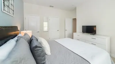 a bedroom with a large bed and a television at Sea Haven in Orlando