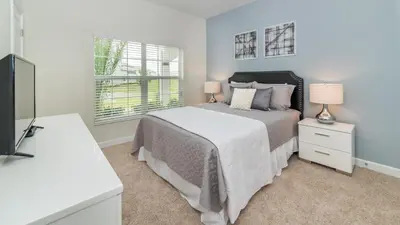 a bedroom with a bed and two lamps and a television at Sea Haven in Orlando