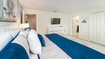 a bedroom with a large bed with blue and white pillows at Sea Haven in Orlando