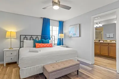 a bedroom with a large bed with blue curtains at Lake view Pool home near Disney - 5BR 4BA in Kissimmee