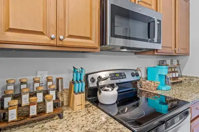 a kitchen counter with a stove and a microwave at Lake view Pool home near Disney - 5BR 4BA in Kissimmee