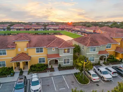 a group of houses with cars parked in a parking lot at Lake view Pool home near Disney - 5BR 4BA in Kissimmee
