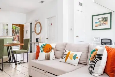 a living room with a white couch with colorful pillows at Your Home Away from Home! in Kissimmee