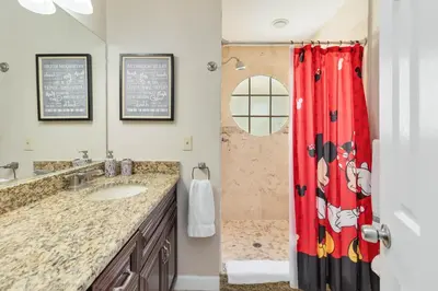 a bathroom with a sink and a red shower curtain at Dream Condo in Kissimmee