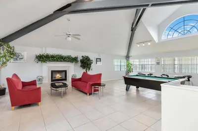 a living room with a pool table and red chairs at Dream Condo in Kissimmee