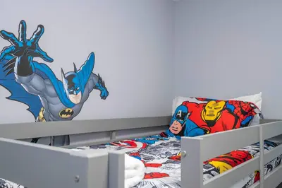 a bedroom with a superhero mural on the wall at Luxury 6BR Resort Home - Pool, Hot Tub & BBQ - Near Disney! in Kissimmee