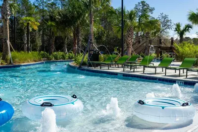 a swimming pool with two water fountains in a resort at Luxury 6BR Resort Home - Pool, Hot Tub & BBQ - Near Disney! in Kissimmee