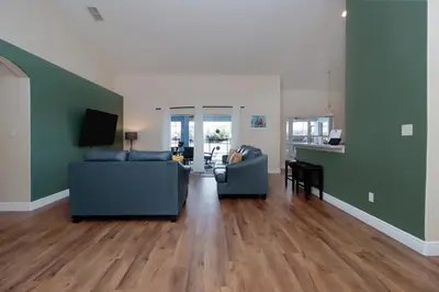 a living room with two blue couches and a kitchen at Orange Tree Vacation Home with Private Pool and Spa Near Disney in Orlando