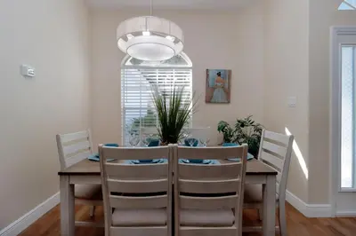 a dining room table with chairs and a potted plant at Orange Tree Vacation Home with Private Pool and Spa Near Disney in Orlando