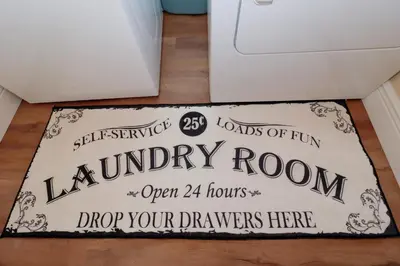 a laundry room sign on a floor next to a washing machine at Orange Tree Vacation Home with Private Pool and Spa Near Disney in Orlando