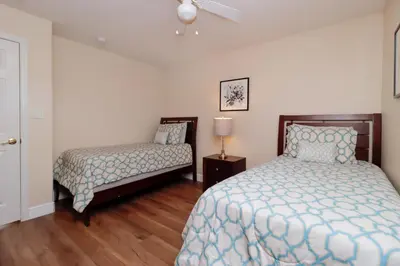 a bedroom with two beds and a night stand with a lamp at Orange Tree Vacation Home with Private Pool and Spa Near Disney in Orlando
