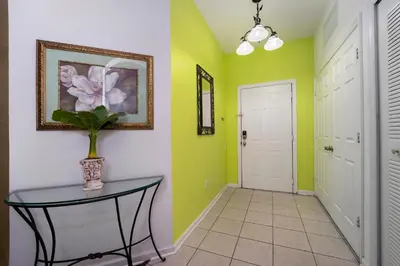 a hallway with green and white walls and a table at Budget Friendly Condo in Windsor Hills Resort w garden view in Orlando