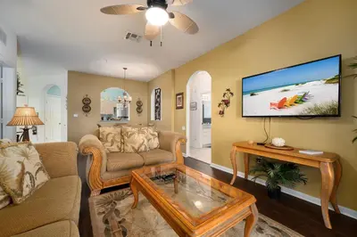 a living room with a couch and a table at Budget Friendly Condo in Windsor Hills Resort w garden view in Orlando