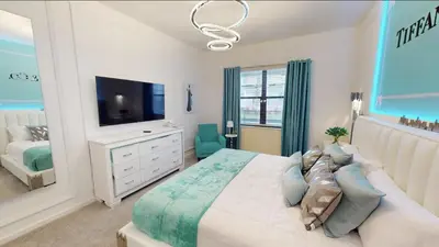 a white bedroom with a large bed and a tv at Paradiso Grande 8BD Games Themed Rooms & Pool Spa in Orlando