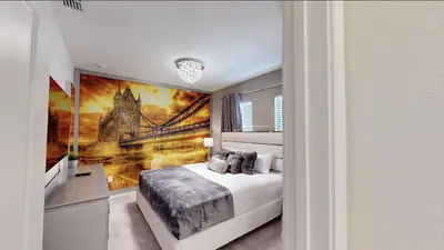 a bedroom with a bed and a painting of a bridge at Paradiso Grande 8BD Games Themed Rooms & Pool Spa in Orlando