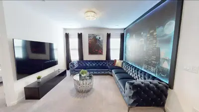 a living room with a black leather couch at Paradiso Grande 8BD Games Themed Rooms & Pool Spa in Orlando