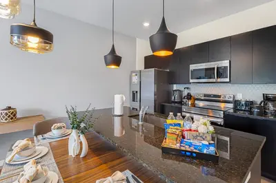 a kitchen with black cabinets and a counter top at 3240 Townhouse Perfect for Disney Visits 3BD in Kissimmee