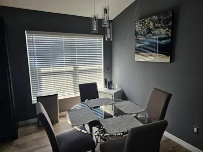 a dining room with a table and chairs and a window at Mufasa's Pride in Kissimmee