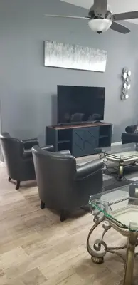 a living room with two chairs and a table at Mufasa's Pride in Kissimmee